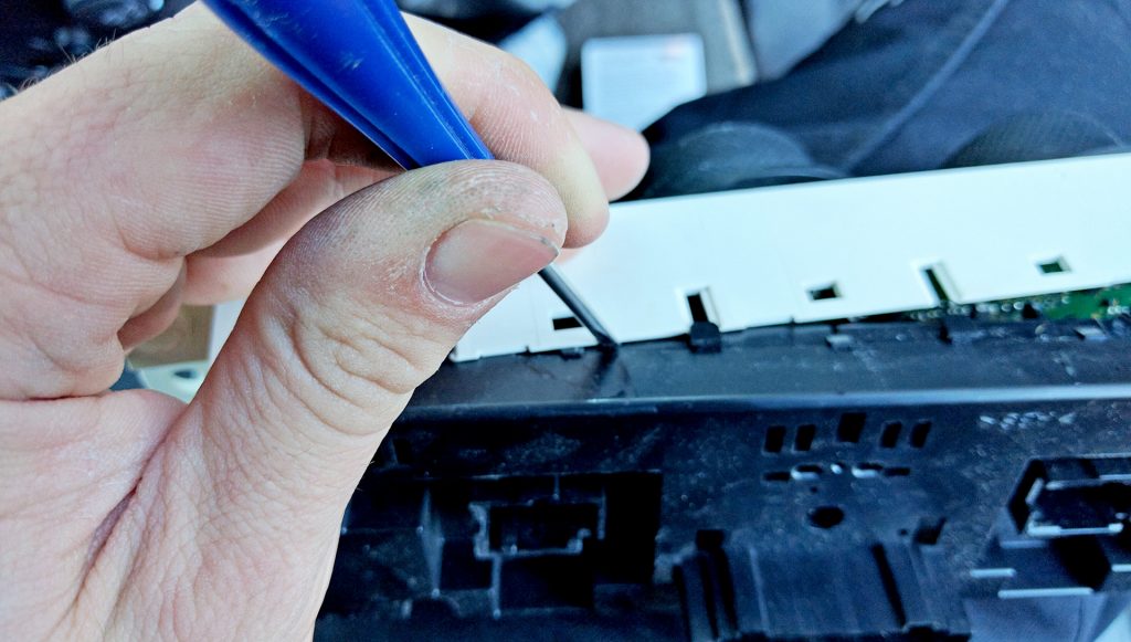 Prying Open H3 Hummer HVAC fixing a light bulb